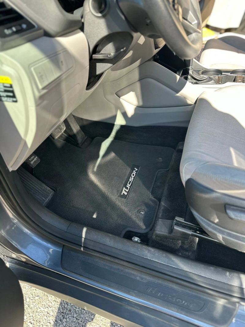 Interior view of a clean car showing floor mats and seats, representative of auto detailing services.