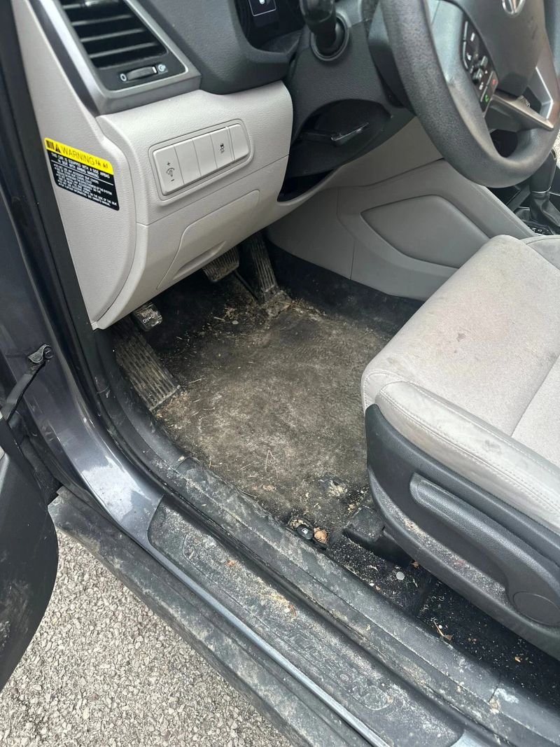Dirty car interior showing dirty floor and seats, highlighting the need for interior detailing services.